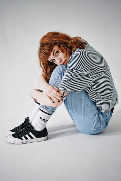 Woman in Black and White Striped Short Sleeve Shirt and Blue Denim Jeans