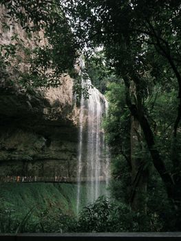 Stunning waterfall cascading through a lush, verdant forest, offering a serene nature escape.