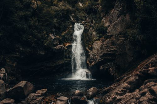 Free Stunning view of a tranquil waterfall amidst rocky cliffs and lush greenery in Tasman, New Zealand. Stock Photo