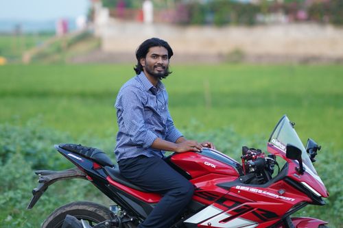 Free Young man on a stylish red motorcycle enjoying a ride through the scenic countryside. Stock Photo