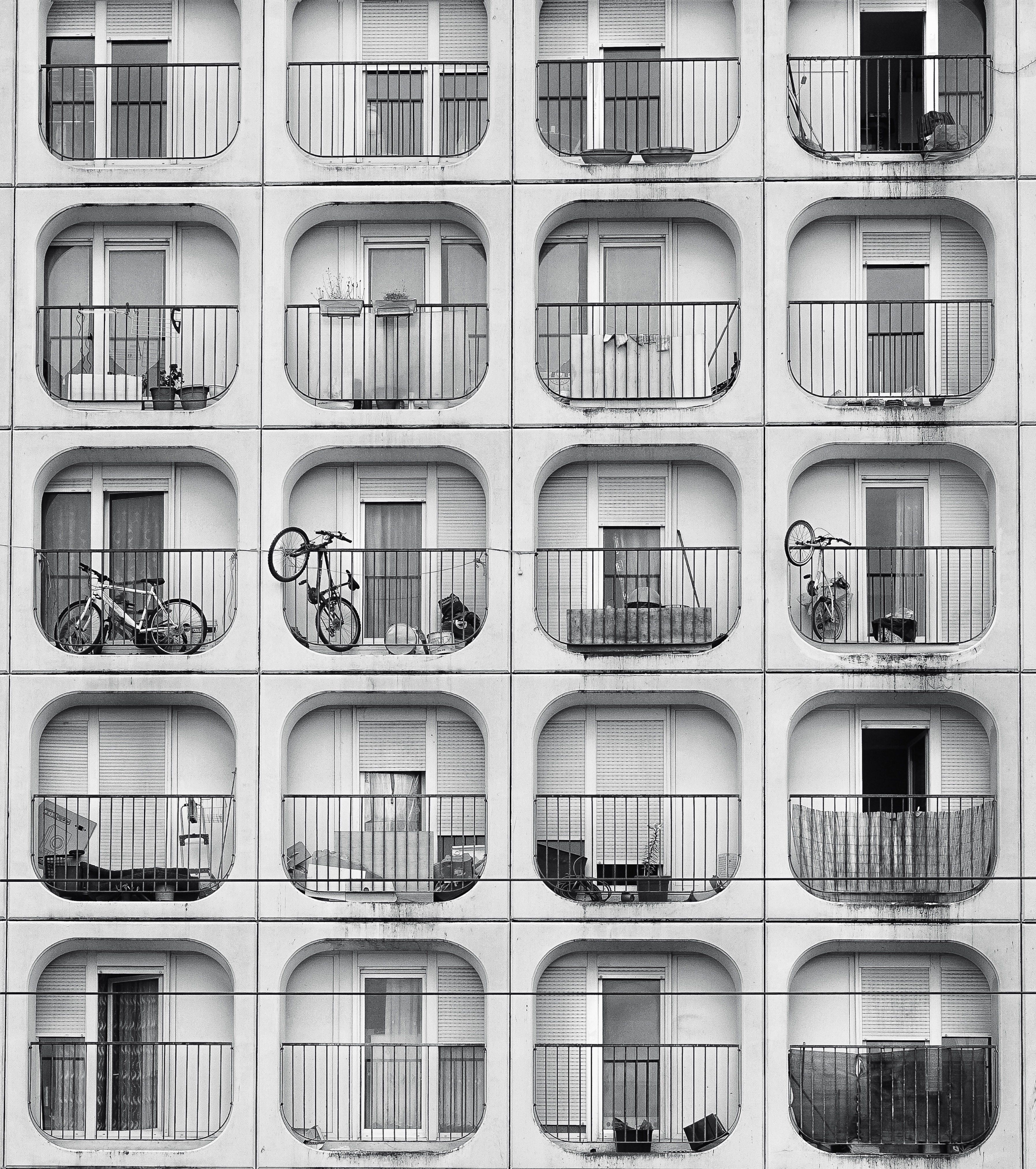 Black and white photo of apartment balconies in Bordeaux, highlighting symmetry and bicycles.