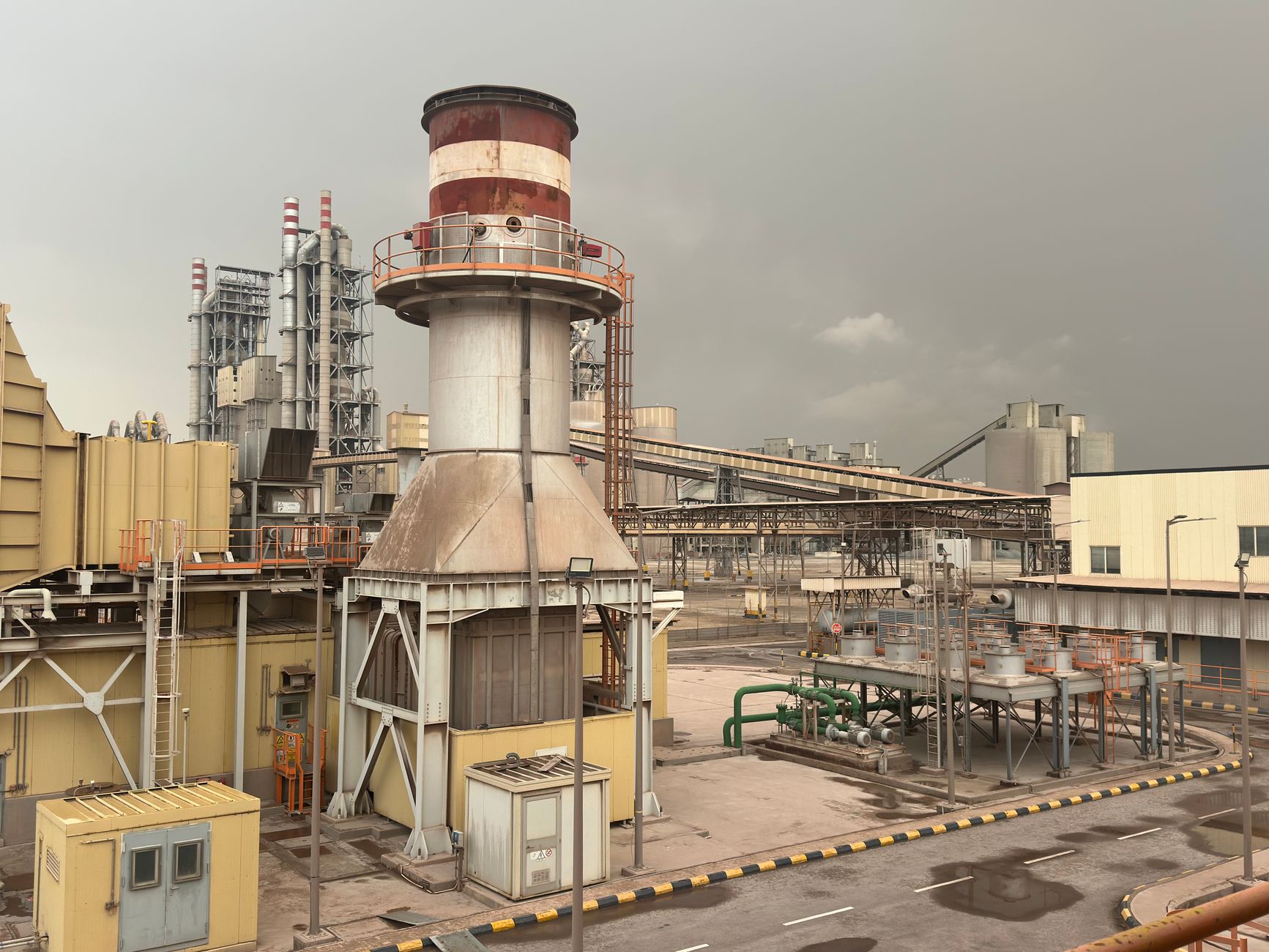 A large industrial facility on a cloudy day in Saudi Arabia, showcasing structures and machinery.