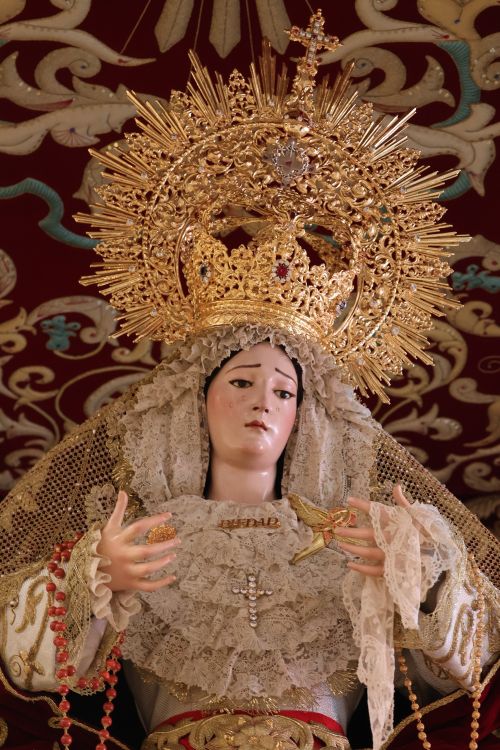 Free Intricate statue of the Virgin Mary adorned with a golden crown in a religious setting. Stock Photo