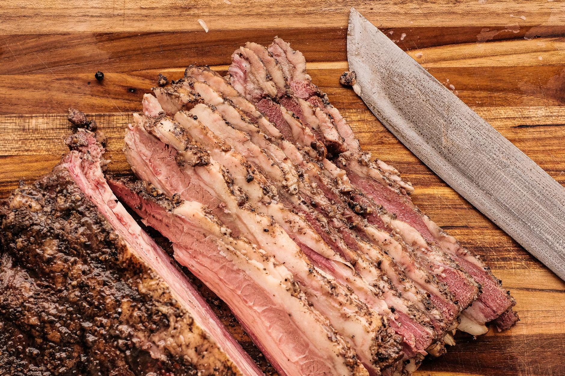 Hands trimming fat from affordable brisket before smoking
