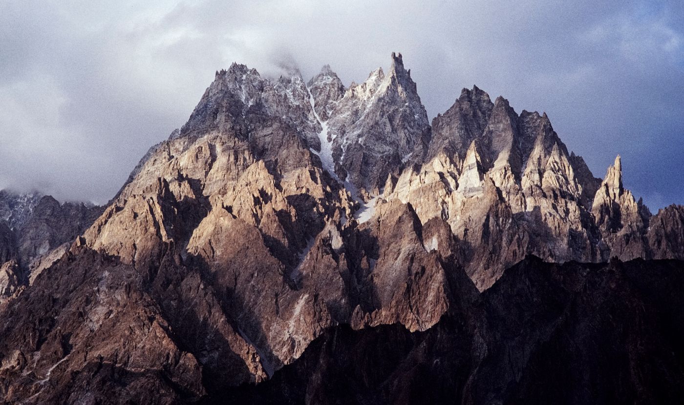 Rocky, snow-streaked peaks of the Karakoram Range in Pakistan lit at sunrise