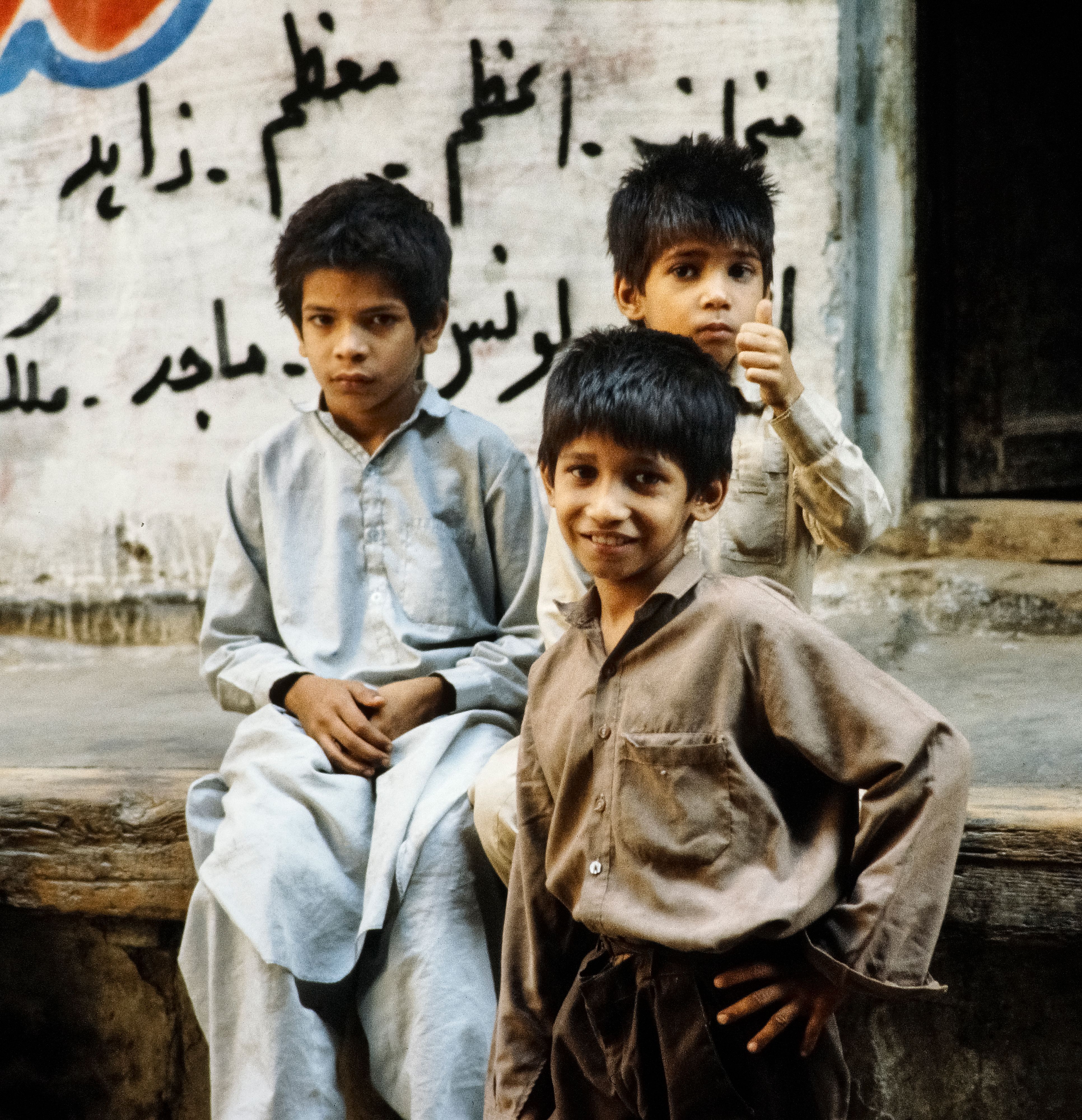 Portrait of Three Boys Sitting Outside in Pakistan · Free Stock Photo