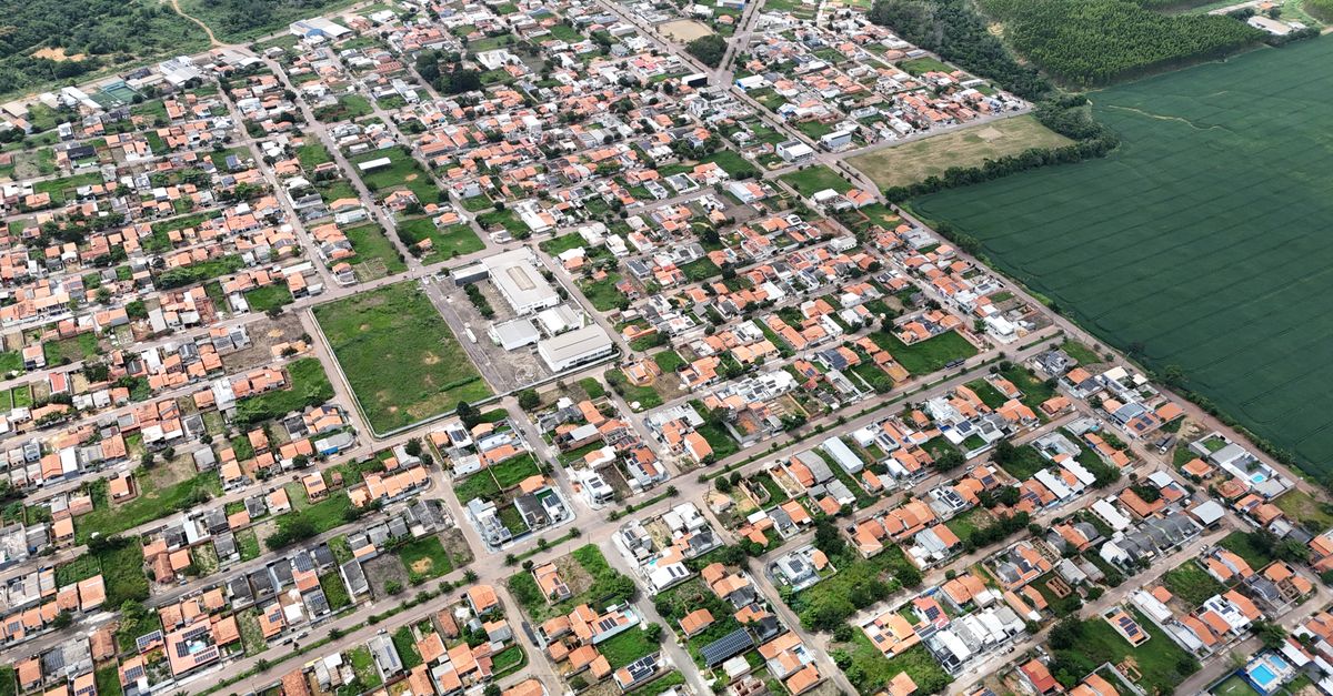 Vista aérea de uma área urbana afetada por enchente, com casas parcialmente submersas e ruas alagadas, simbolizando a necessidade de seguro residencial contra danos causados pela água.