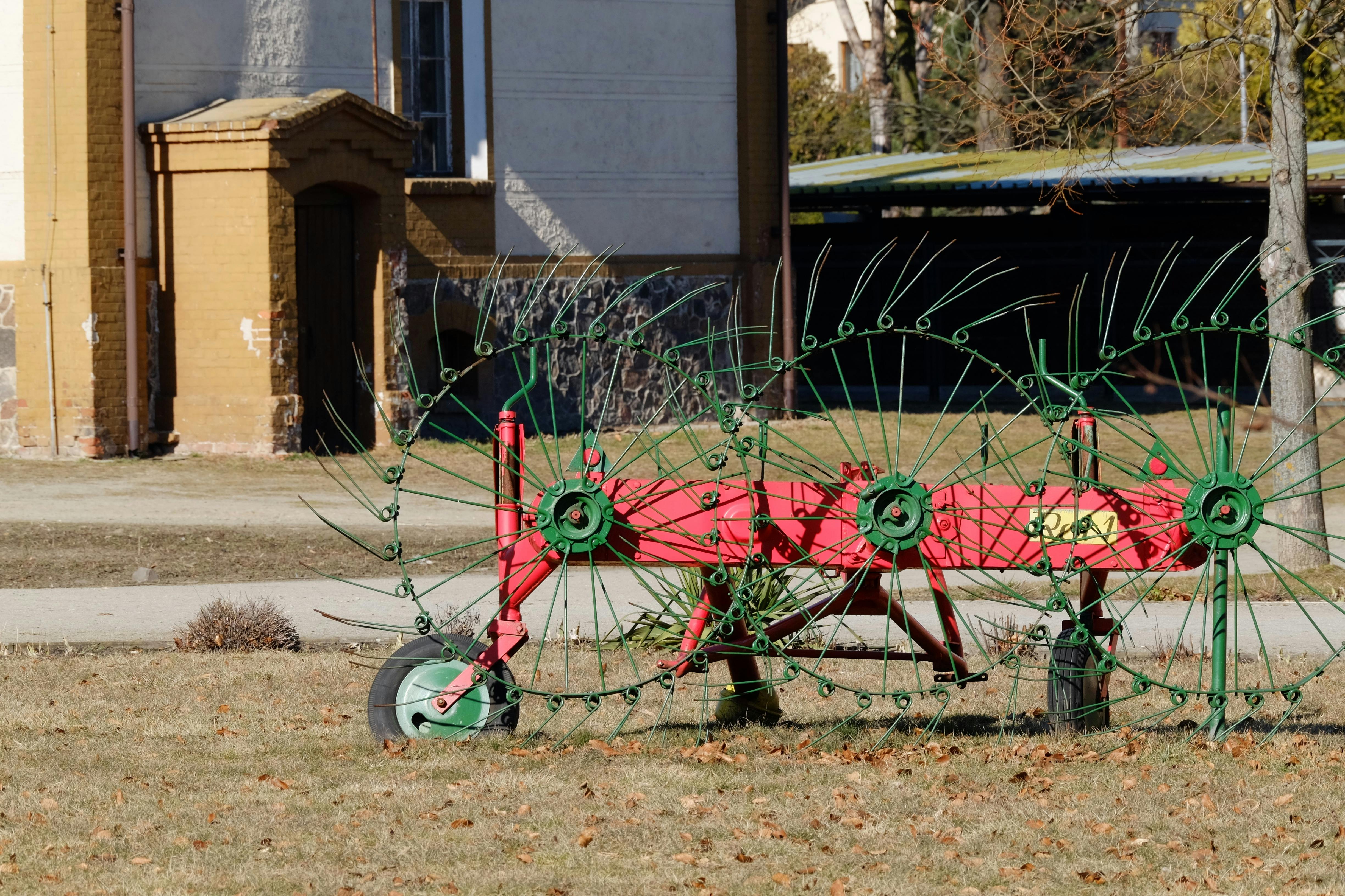 Rustic vintage farm equipment displayed in an outdoor rural setting under daylight.