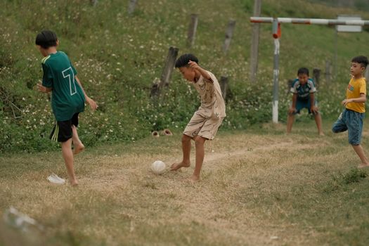 Group of kids playing football outdoors, having fun on a sunny day.