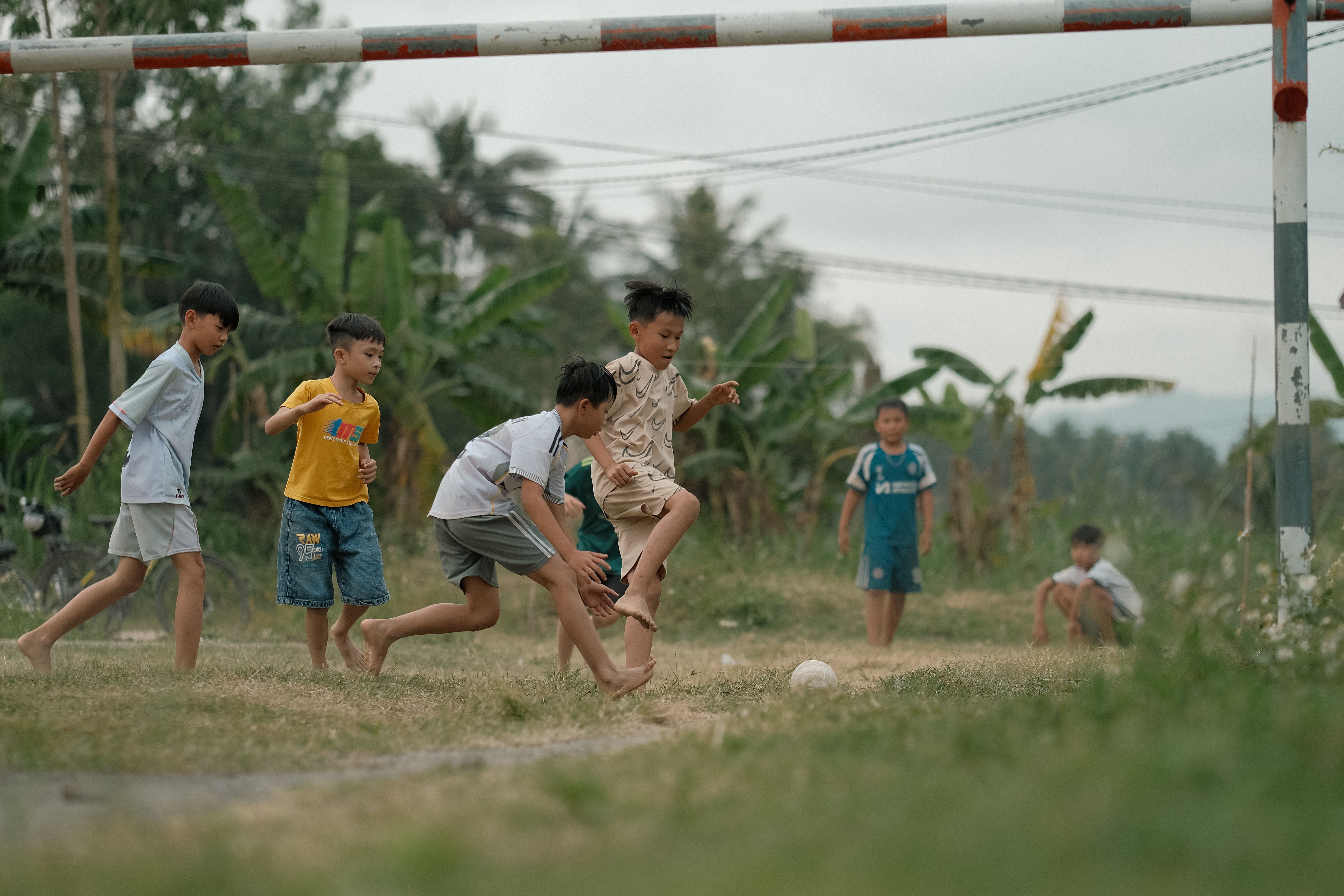 Group of kids joyfully playing soccer in a grassy outdoor field. - Photo by Pew Nguyen on Pexels