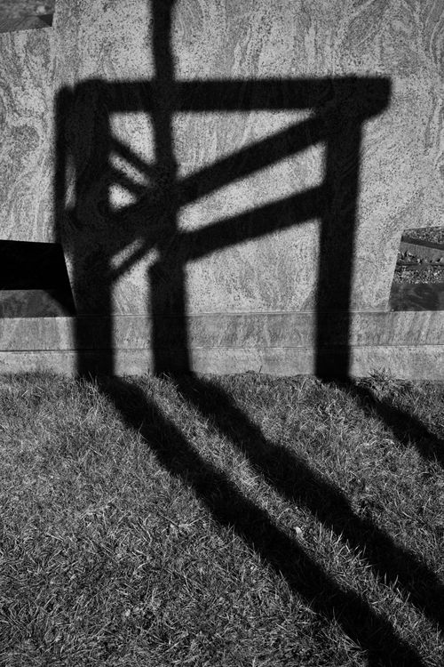 Free A black and white abstract image of a chair's shadow cast on grass. Stock Photo