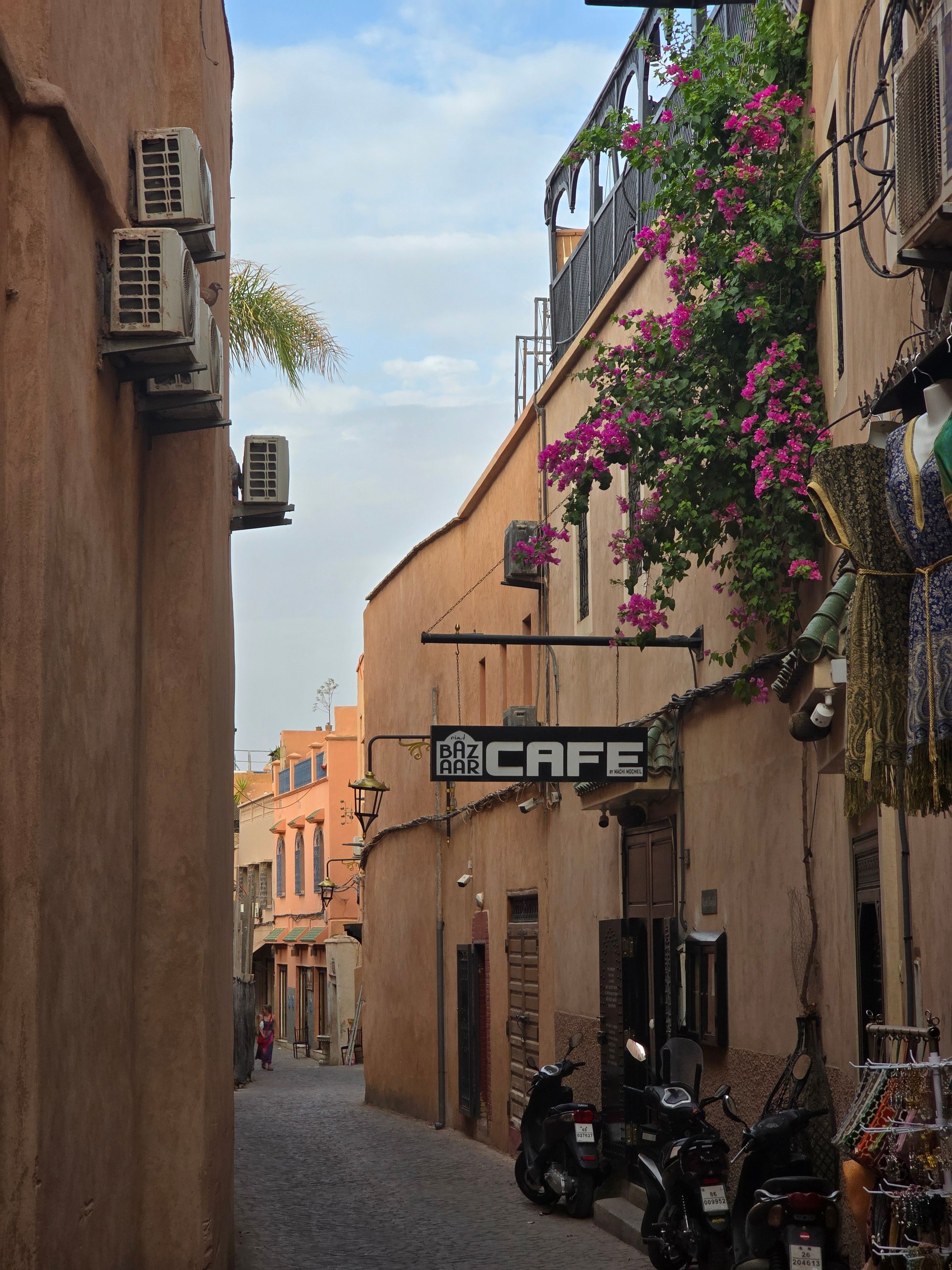 Discover a quaint alleyway with a café in the historic Medina of Marrakech, Morocco, offering local color and culture.