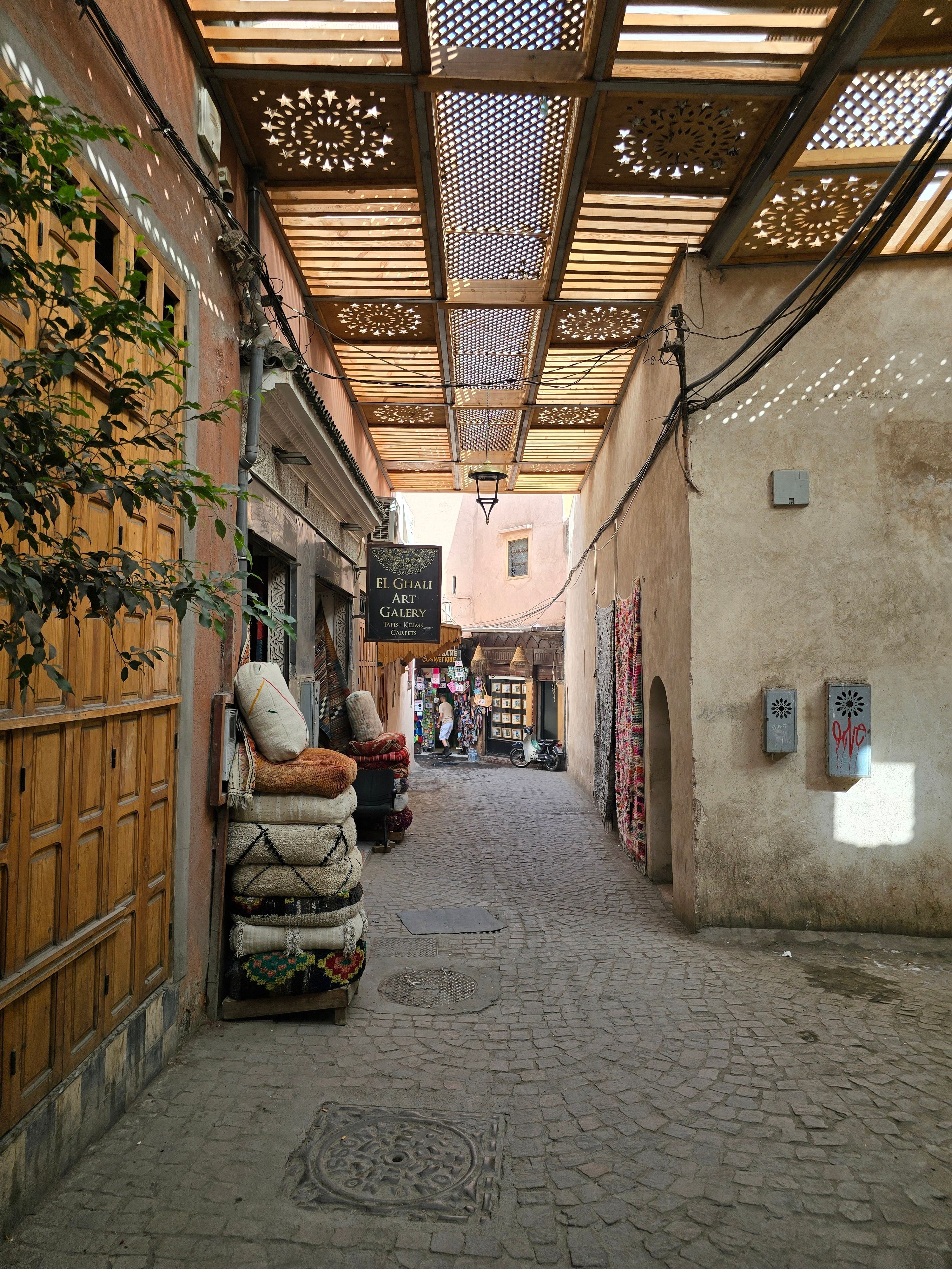Explore a serene alleyway in the Marrakech Medina filled with rugs and cultural artistry.
