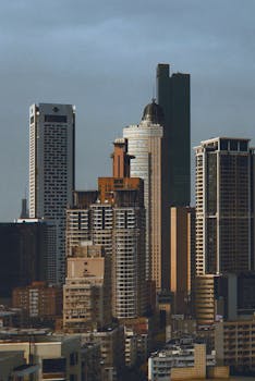 Aerial view of Nanjing's modern skyscrapers under a cloudy sky.