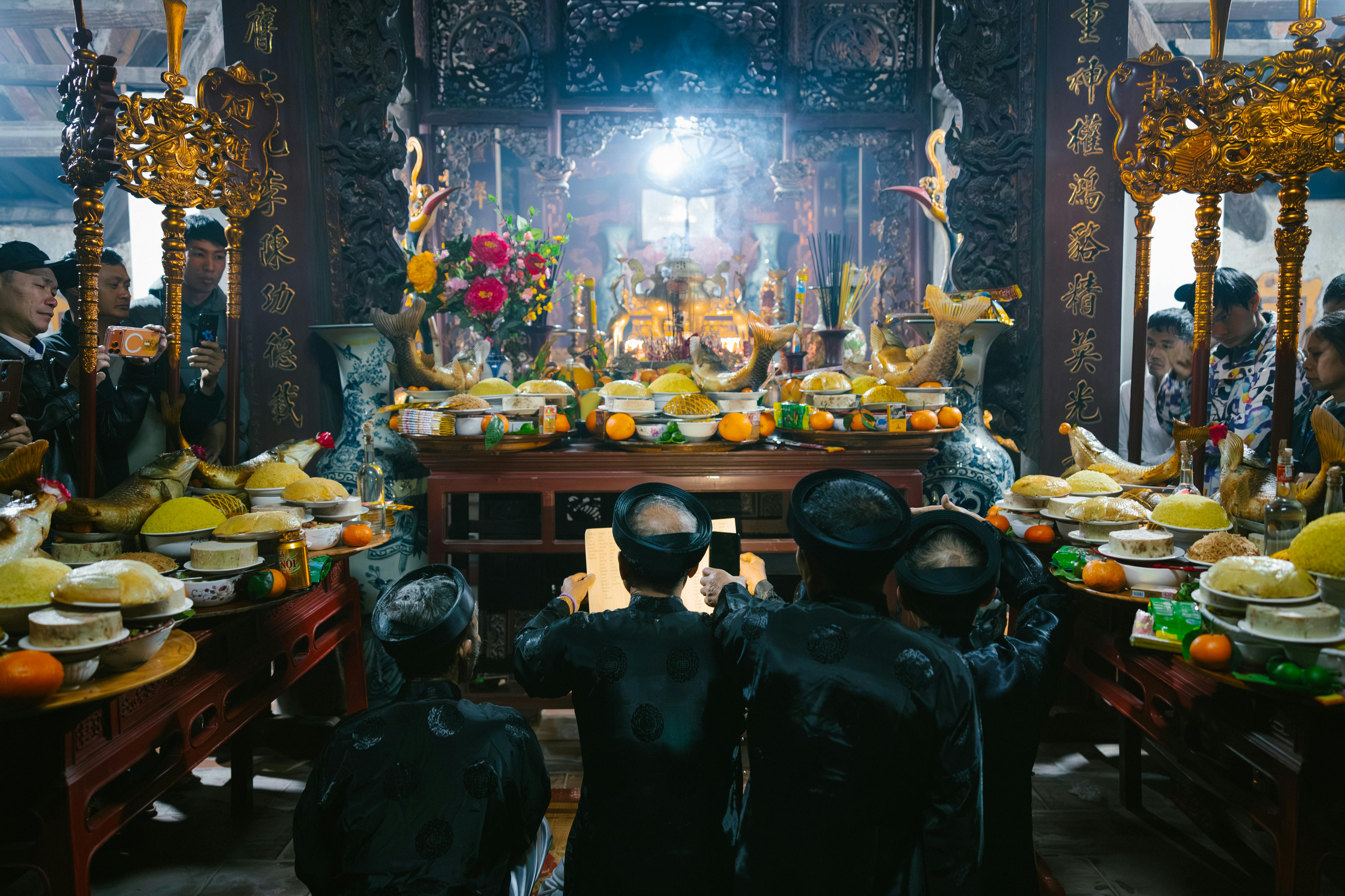 A vibrant traditional ceremony inside a temple with offerings and worshippers.