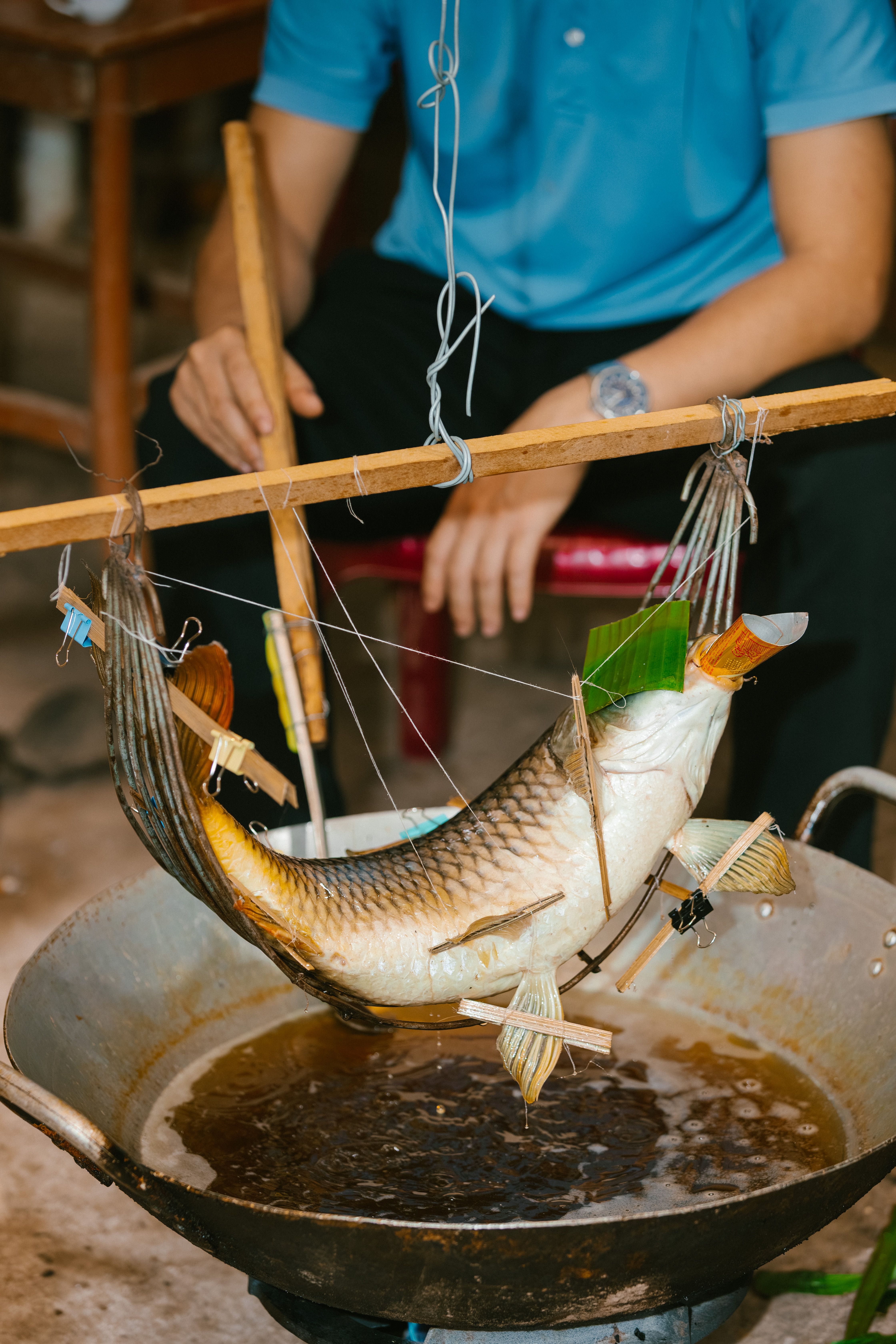 Men Cooking Fish Over Open Flame Indoors · Free Stock Photo