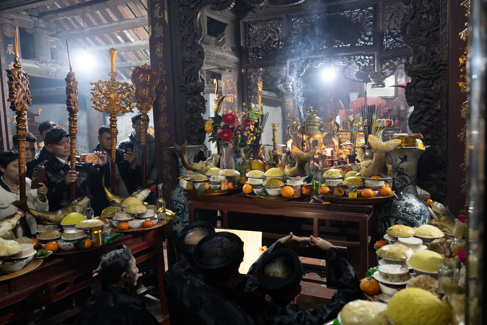 A vibrant indoor scene capturing a traditional religious ceremony with colorful offerings and decorations.