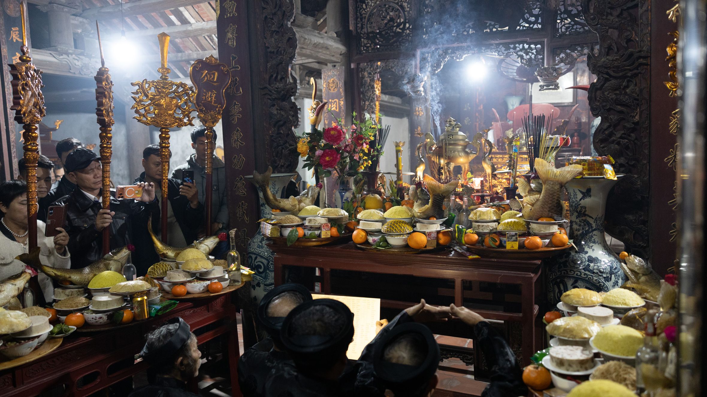 A vibrant indoor scene capturing a traditional religious ceremony with colorful offerings and decorations.