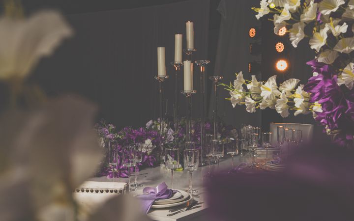 Luxurious dining setup with candles and floral decor, perfect for weddings and formal events.