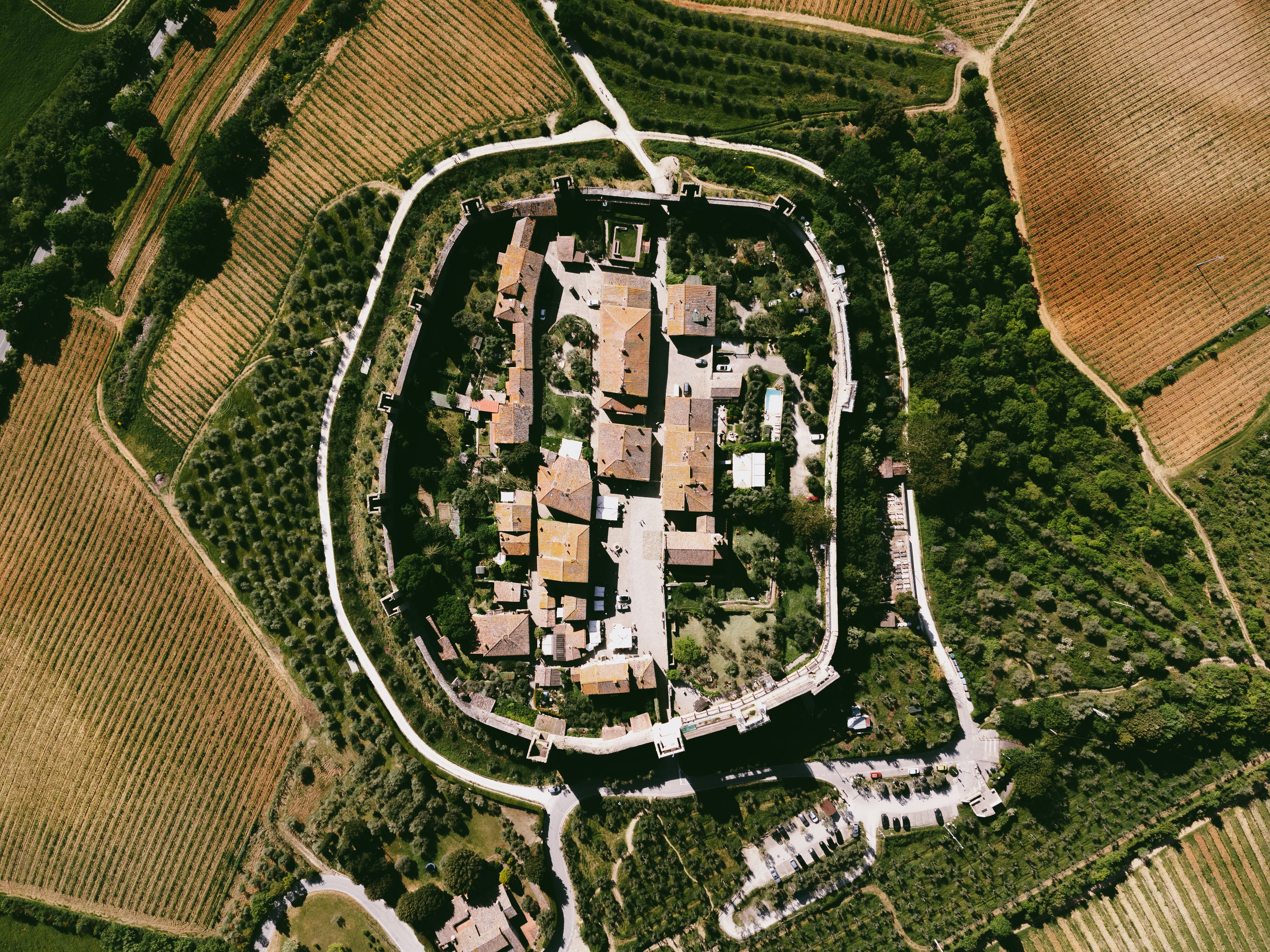 Aerial view of walled medieval village on hilltop surrounded by countryside