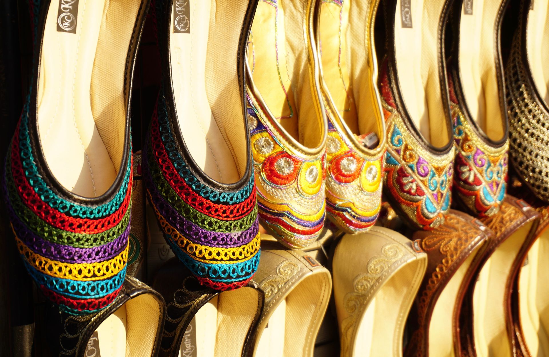 A vibrant collection of embroidered handmade shoes showcasing intricate traditional designs.