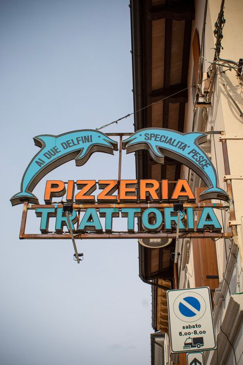 Free Vibrant sign of a pizzeria and trattoria in Palmanova, showcasing local Italian culture. Stock Photo