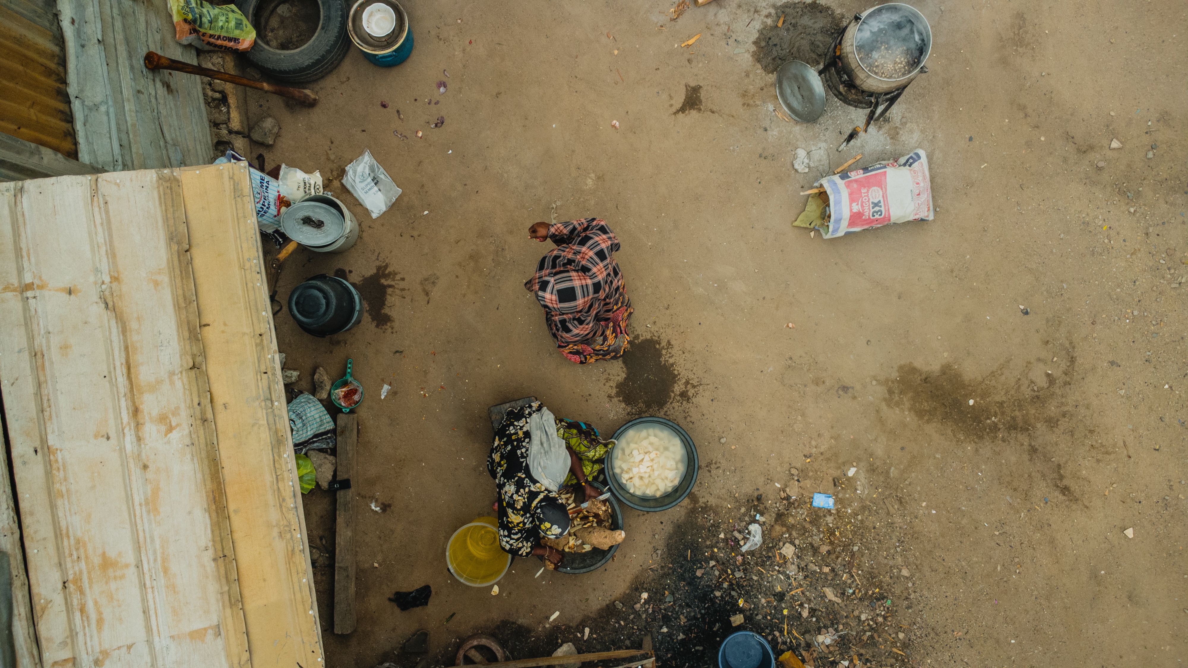 Captured from above, a woman cooks outdoors in Abuja, Nigeria.