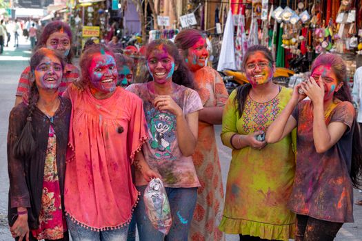 Joyful group celebrating Holi in Nashik, India with vibrant colors and smiles.