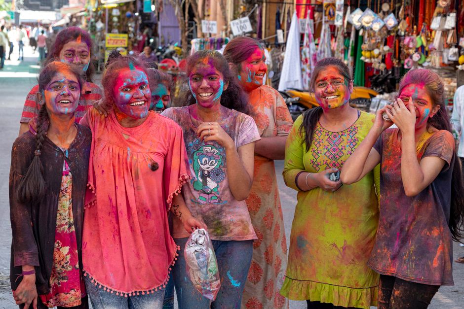Joyful group celebrating Holi in Nashik, India with vibrant colors and smiles.