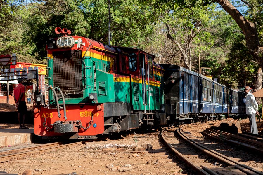 A vibrant narrow gauge train in Matheran, Maharashtra, highlighting local culture and travel routes.