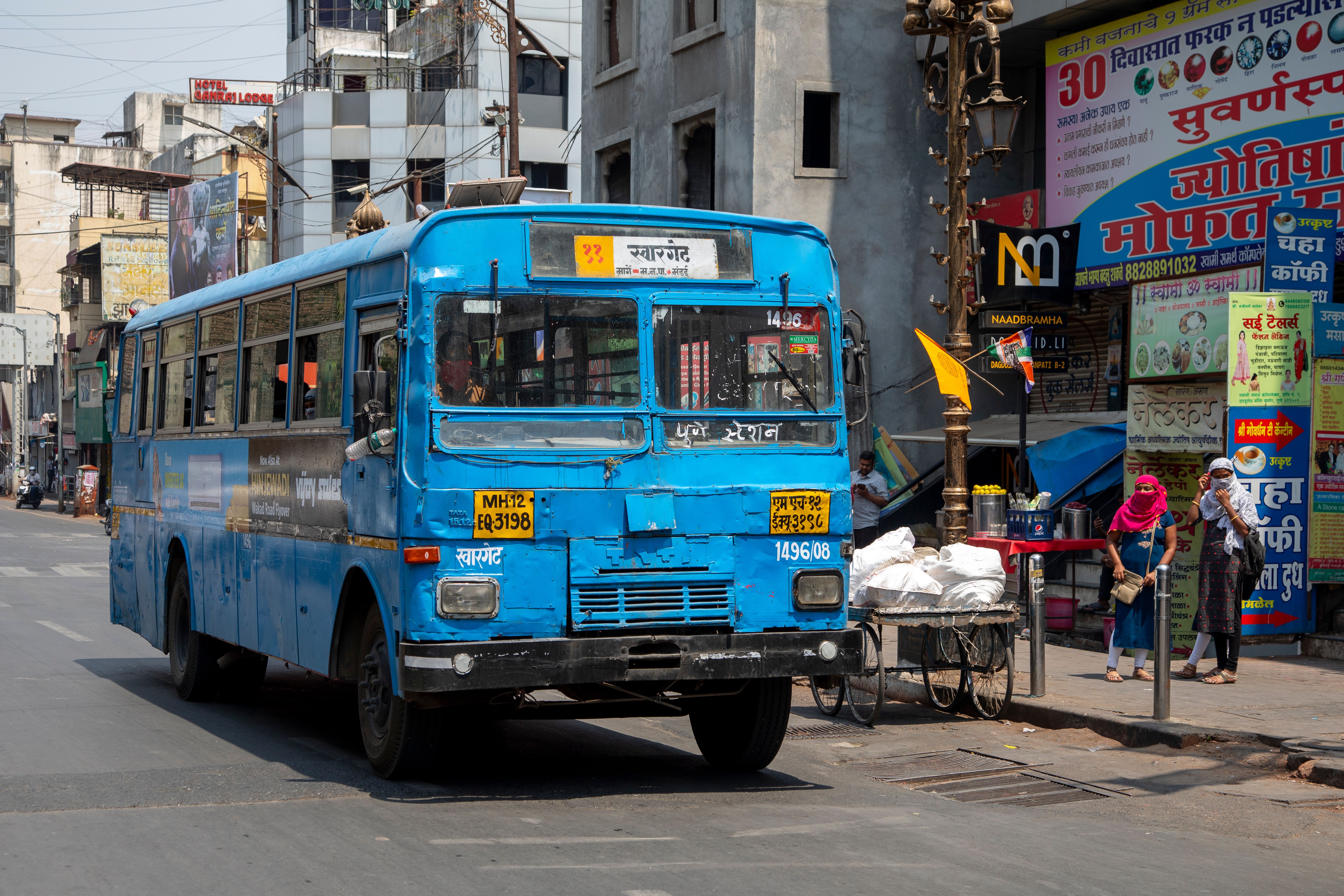 A blue public bus on a busy Indian street