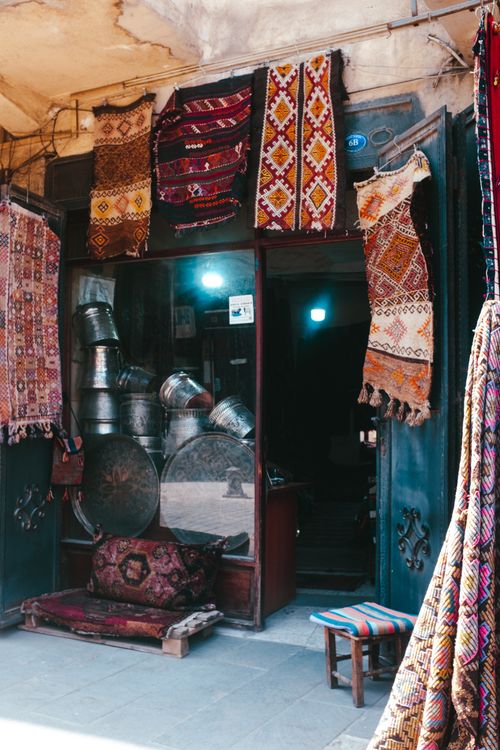 Free Charming market storefront displaying colorful oriental rugs and metalware. Stock Photo