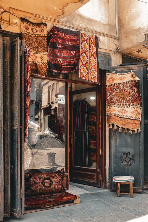 Free Entrance of a carpet shop displaying colorful handmade rugs in a historic bazaar. Stock Photo