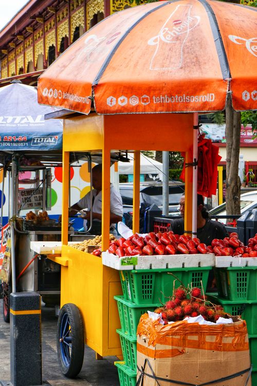 Free Colorful street market scene with fruit stand offering diverse tropical fruits in Jakarta, Indonesia. Stock Photo