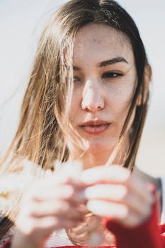 一位长发年轻女子手持鲜花在户外的特写肖像