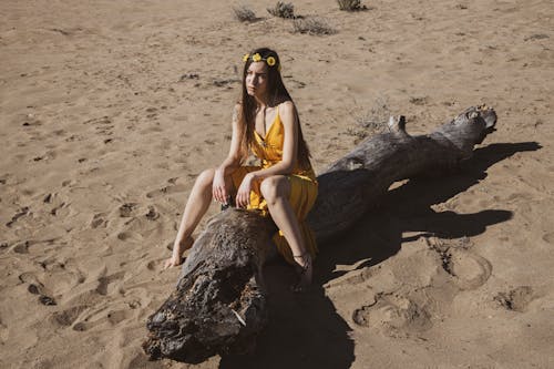 Woman in Yellow Dress Sitting on Trunk