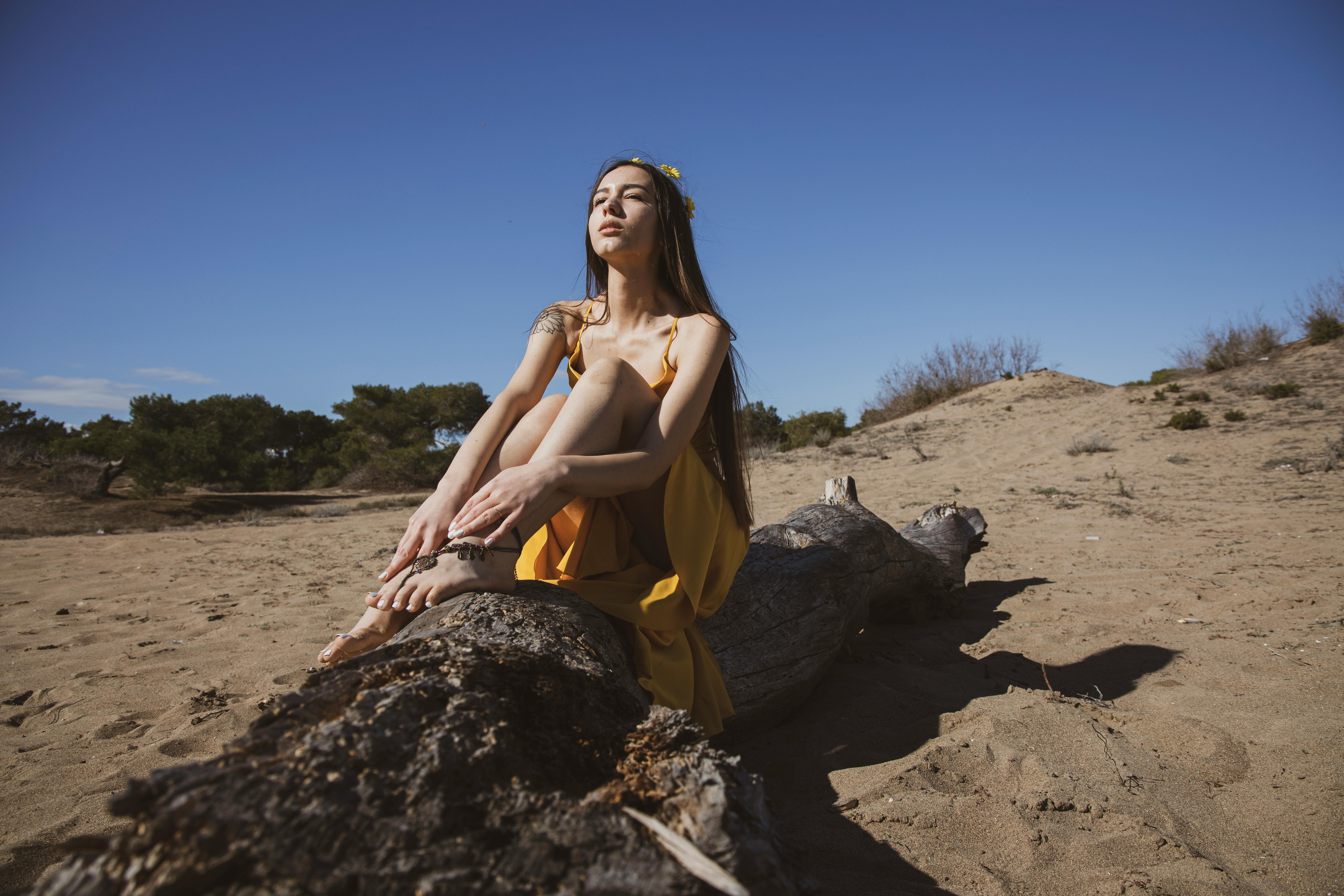 一位时尚女性穿着黄色连衣裙，在土耳其风景秀丽的海滩上放松