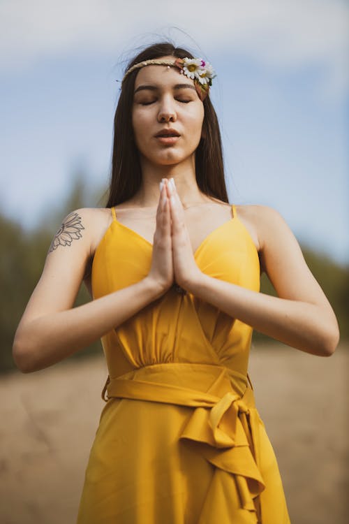 Free Woman in Yellow Dress In A Praying Position Stock Photo