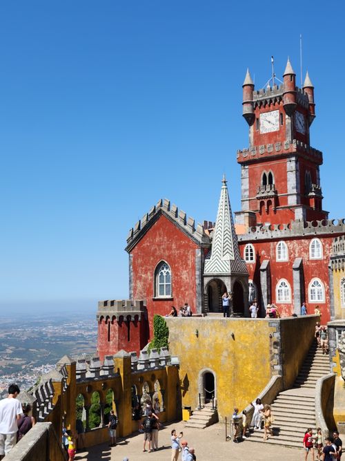Free Colorful architecture of Pena Palace in Sintra, Portugal, under a clear blue sky, drawing visitor admiration. Stock Photo