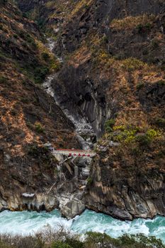 A breathtaking view of Tiger Leaping Gorge in Lijiang, Yunnan, showcasing dramatic cliffs and a raging river.