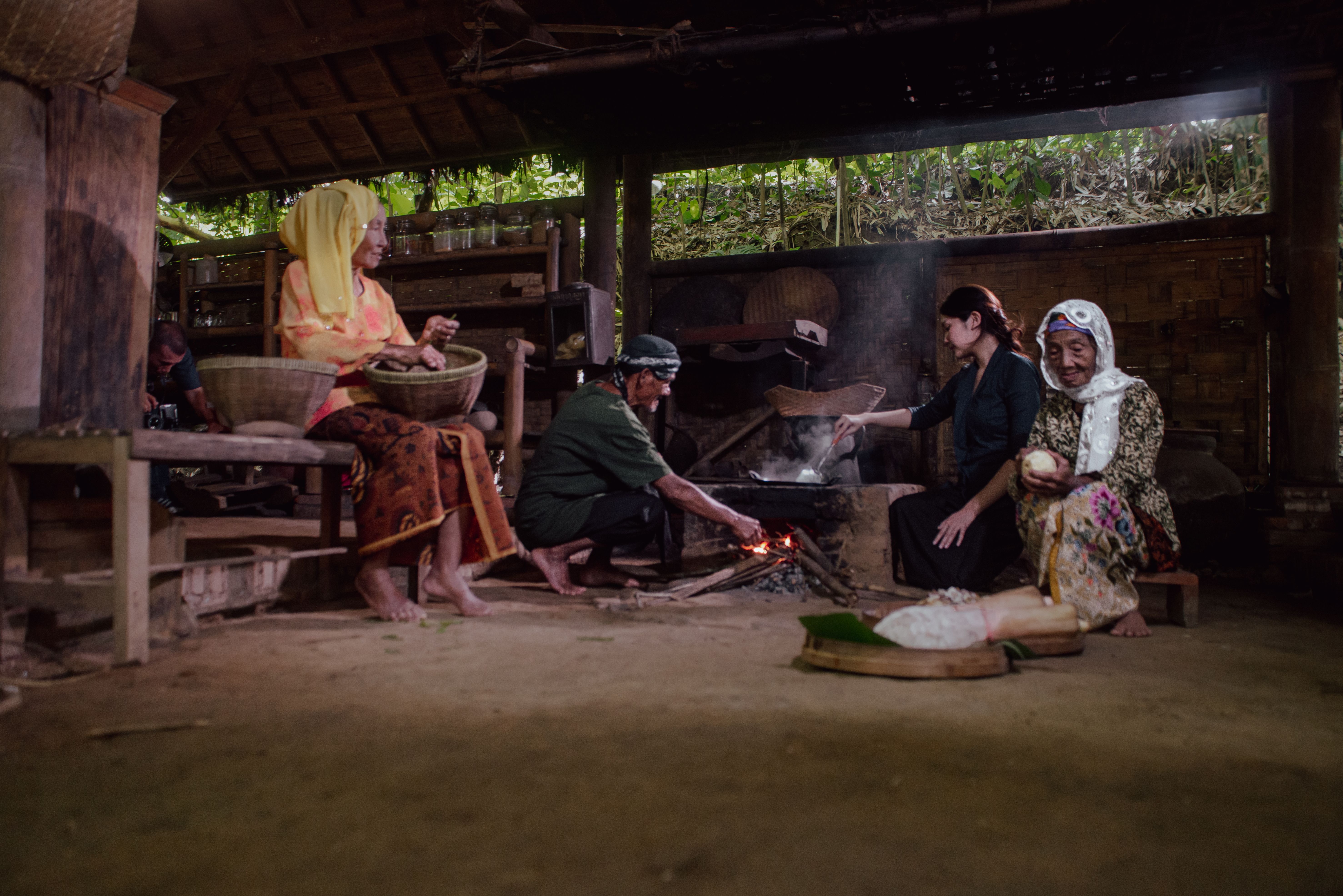 A group of people cooking using traditional methods in Malang, Indonesia, showcasing cultural heritage.