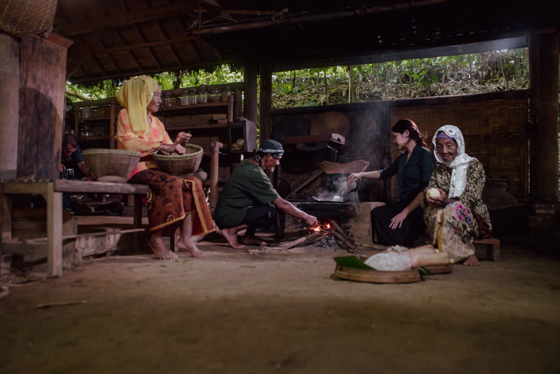 A group of people cooking using traditional methods in Malang, Indonesia, showcasing cultural heritage.
