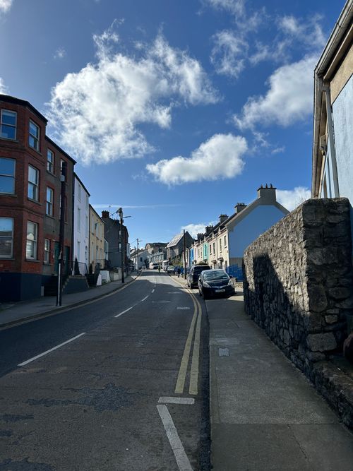 Free Charming street view in Howth, Ireland with colorful houses under a clear blue sky. Stock Photo