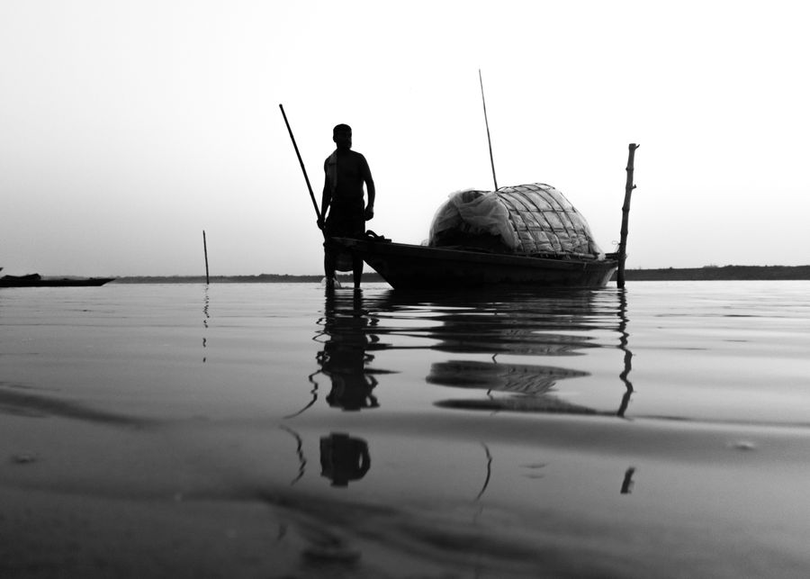 Silhouette of fisherman on calm river in Bangladesh