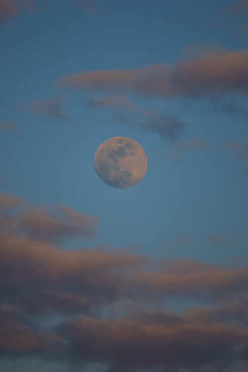 Free The full moon rises amidst scattered clouds in Istanbul's evening sky. Stock Photo