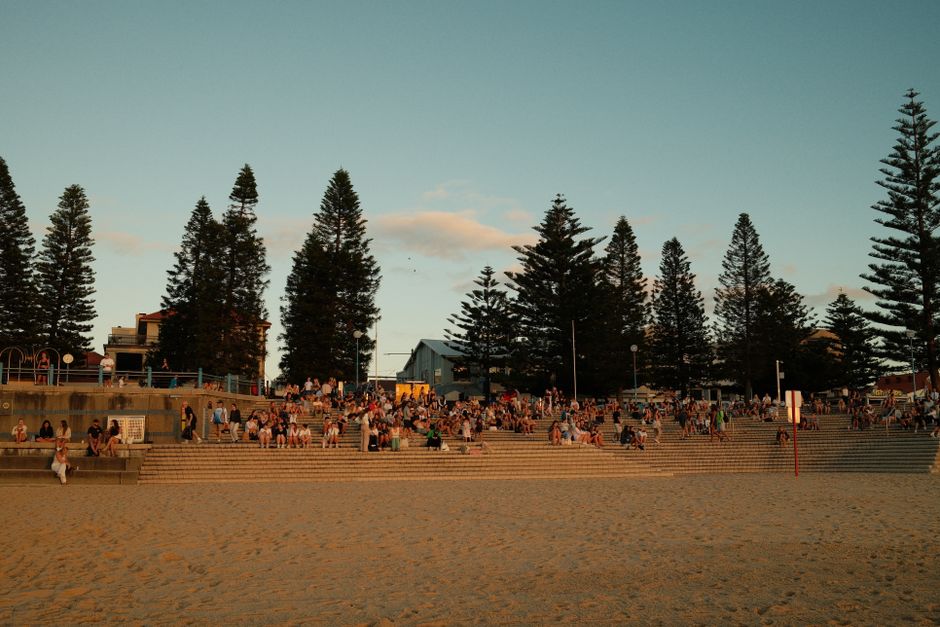 People using a free public BBQ at an Australian beach park