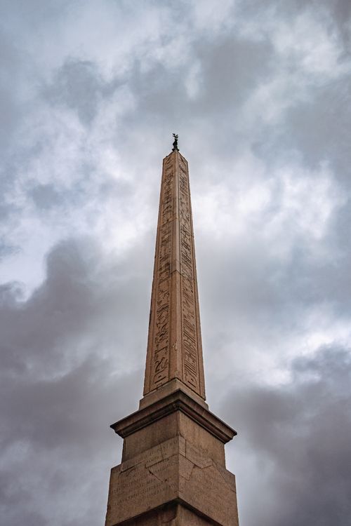 Free Captivating view of an ancient obelisk in Piazza Navona, Rome, against a cloudy, dramatic sky. Stock Photo