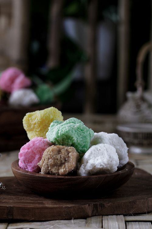 Free Assorted traditional Indonesian cakes in pastel colors displayed on a wooden plate indoors. Stock Photo