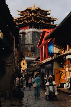 A vibrant Tibetan street scene with a traditional pagoda in Diqing, Yunnan, China.