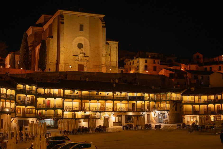 Night view of the illuminated Plaza Mayor and Church of Our Lady of Assumption in Chinchón, Spain.